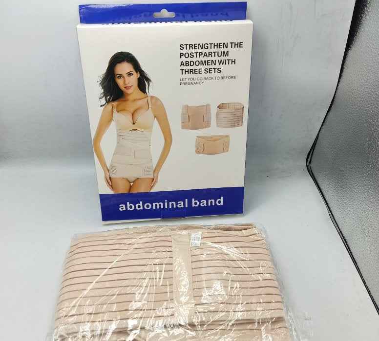 Abdominal band packaging with a woman on it, placed on a white surface.