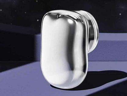 Silver earbud on a reflective surface with a dark background