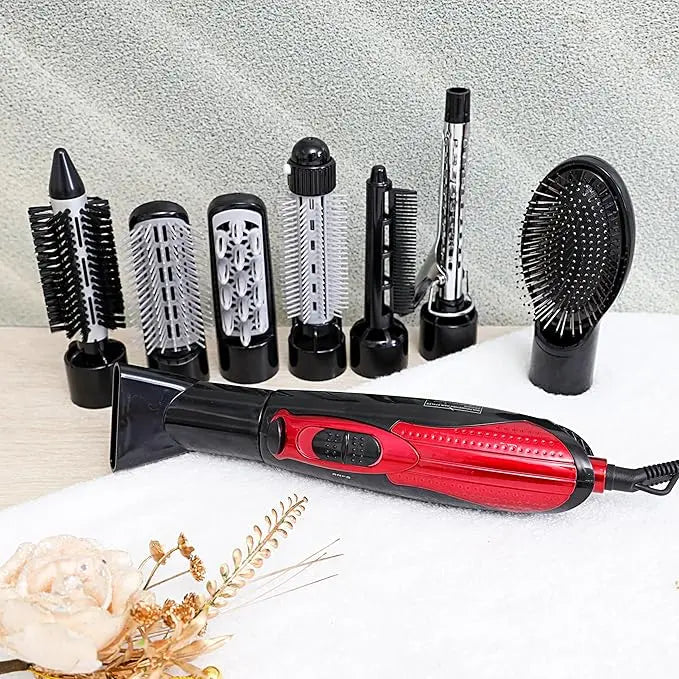 Red and black hair styling tool with multiple attachments on a light surface.