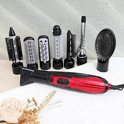 Red and black hair styling tool with multiple attachments on a light surface.